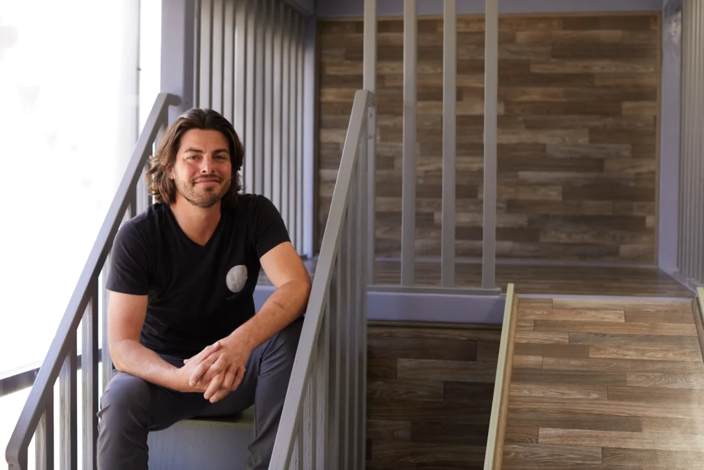 Dustin Grabiner, owner of HK Sensory Gyms, sitting on sensory gym stairs